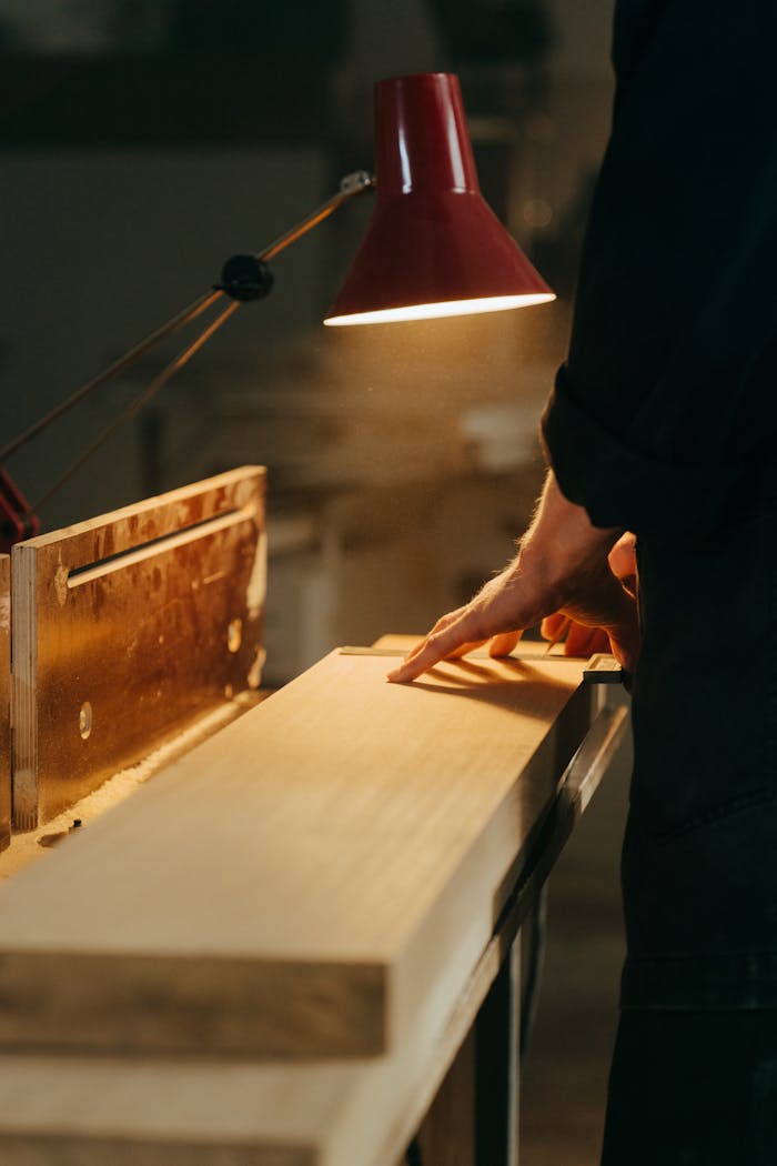 A skilled craftsman handcrafting wood under warm light in a workshop, focusing on precision.